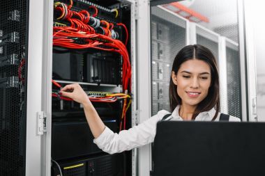 Sunucu odası içinde laptop üzerinde teknisyen portresi