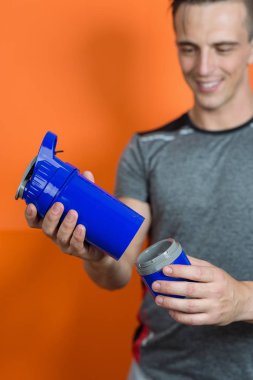 Bir kaşık protein tutan bir vücut geliştirmeciydi portresi karıştırmak içinde jimnastik salonu