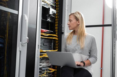 Sunucu odası içinde laptop üzerinde teknisyen portresi