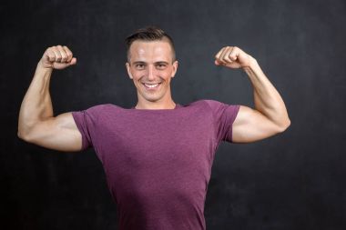 Atletik bir fitness erkek portresi bir spor giyim gri vignette arka plan üzerinde giyinmiş..