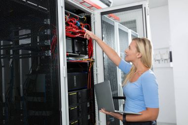 Sunucu odası içinde laptop üzerinde teknisyen portresi