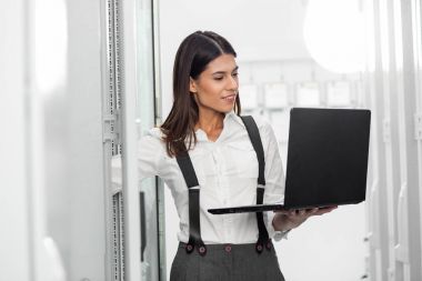 Sunucu odası içinde laptop üzerinde teknisyen portresi