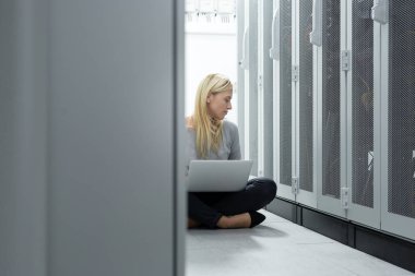 Sunucu odası içinde laptop üzerinde teknisyen portresi