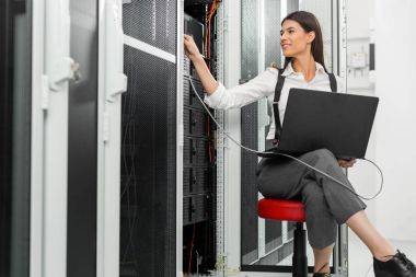 Sunucu odası içinde laptop üzerinde teknisyen portresi