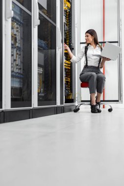 Sunucu odası içinde laptop üzerinde teknisyen portresi