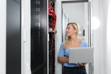 Sunucu odası içinde laptop üzerinde teknisyen portresi