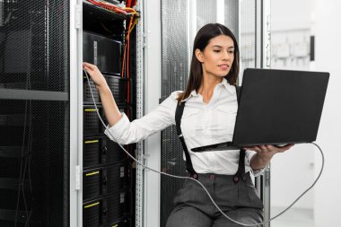 Sunucu odası içinde laptop üzerinde teknisyen portresi