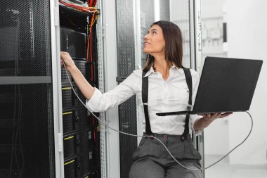 Sunucu odası içinde laptop üzerinde teknisyen portresi