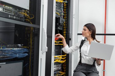 Sunucu odası içinde laptop üzerinde teknisyen portresi