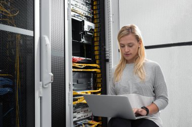 Sunucu odası içinde laptop üzerinde teknisyen portresi