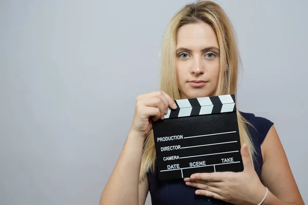 Young woman in action, holding clapperboard. Cinema concept