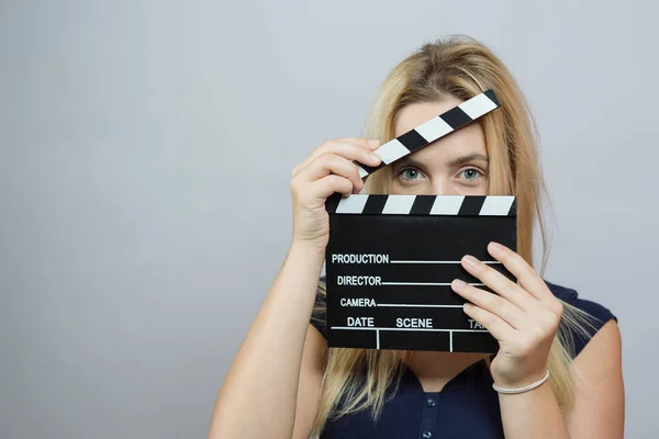 Young woman in action, holding clapperboard. Cinema concept