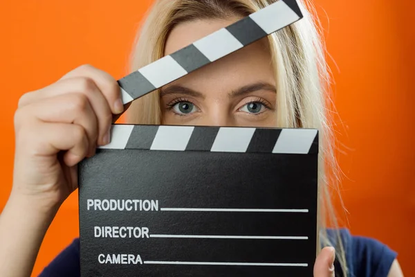 Young woman in action, holding clapperboard. Cinema concept