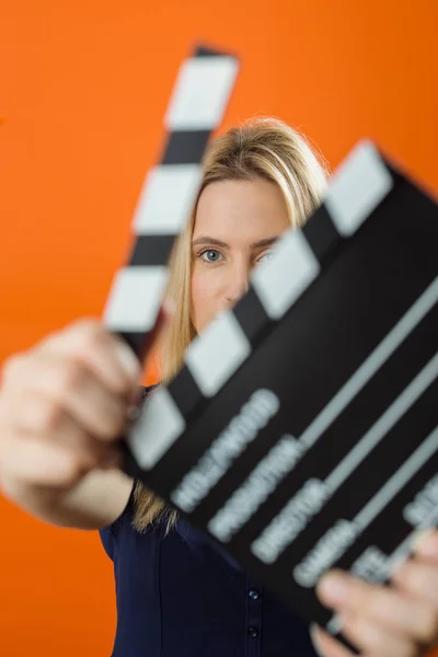 Young woman in action, holding clapperboard. Cinema concept