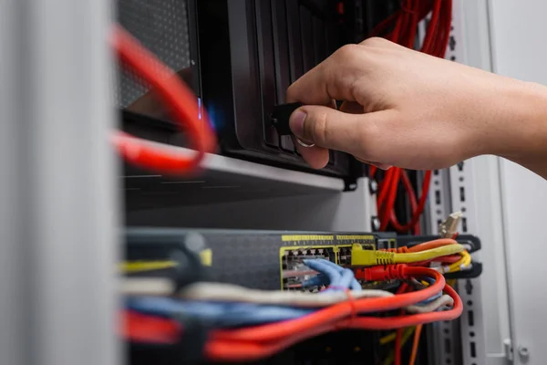 Hand fixing cables in network server room routers