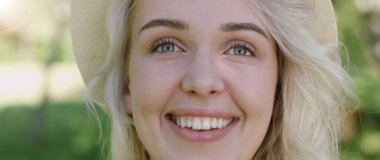 Poz ve güneşli yaz gündüz dışarıda gülümseyen güzel genç kadın