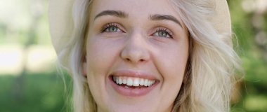 Poz ve güneşli yaz gündüz dışarıda gülümseyen güzel genç kadın