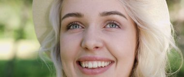 Poz ve güneşli yaz gündüz dışarıda gülümseyen güzel genç kadın