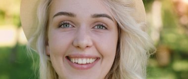 Poz ve güneşli yaz gündüz dışarıda gülümseyen güzel genç kadın