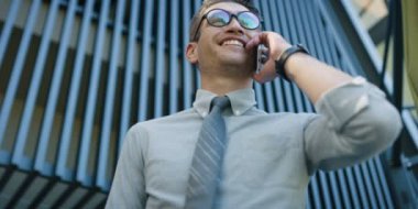 Beyaz gömlek cep telefonu ofis binası önünde konuşurken genç adam 
