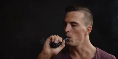 Erkekler siyah arka plan vaping ve Buhar bulutu serbest bırakır.