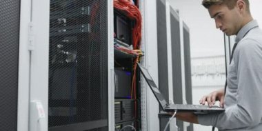 Dizüstü tutarak ve sunucu, veri merkezi kontrol genç yakışıklı mühendis Close-Up 