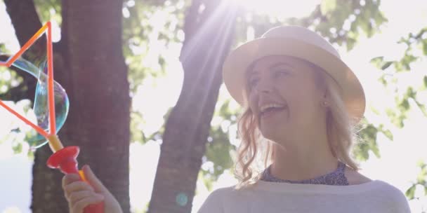 Splendida Ragazza Bionda Che Soffia Bolle Sapone Nel Parco — Video Stock