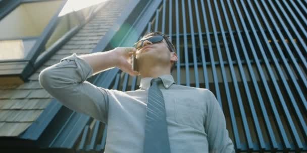 Schöner Geschäftsmann Mit Sonnenbrille Und Smartphone Freien Vor Modernem Hintergrund — Stockvideo