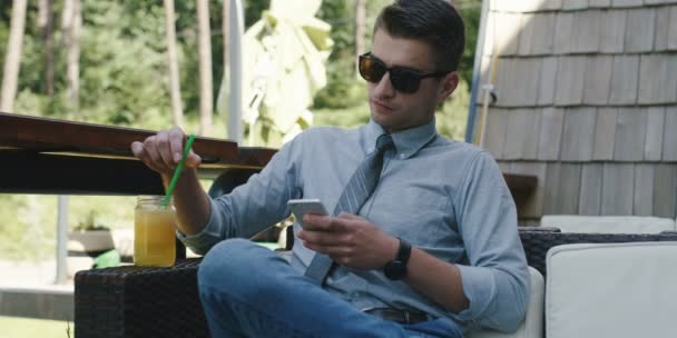 Guapo Hombre Negocios Gafas Sol Sosteniendo Utilizando Teléfono Inteligente Cafetería — Vídeo de stock