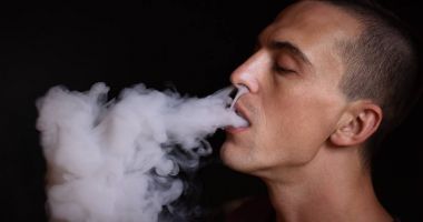 Yakışıklı delikanlı vaping siyah arka plan üzerine Closeuo