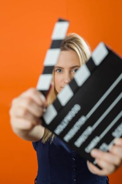 Stüdyoda bir film clapper tutan kadın