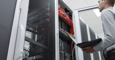 Sunucu odasına dizüstü bilgisayar ile bir sorunu gidermekle genç uzman tehnician