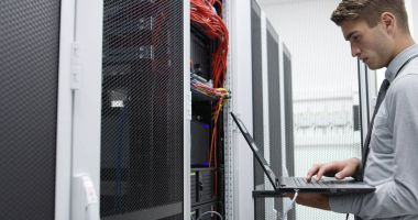 Sunucu odasına dizüstü bilgisayar ile bir sorunu gidermekle genç uzman tehnician