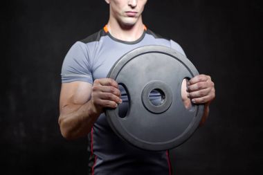 siyah arka plan üzerine dumbbells ile egzersiz genç kaslı adam