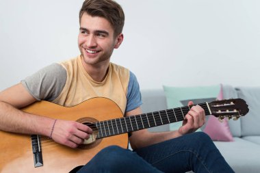 Yakışıklı genç oyuncu evde bir gitar çalmak. Entertaiment zaman