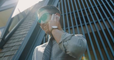 Ofis dışında cep telefonu ile iş adamı. Ofis onun arkasında Binası çelik satırlarından