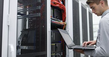 Sunucu odasına dizüstü bilgisayar ile bir sorunu gidermekle genç uzman tehnician