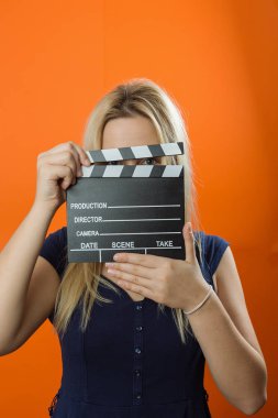 Stüdyoda bir film clapper tutan kadın