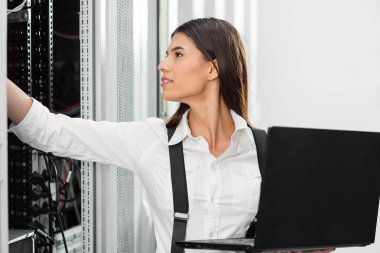 Sunucu odasına dizüstü bilgisayar ile bir sorunu gidermekle genç uzman tehnician