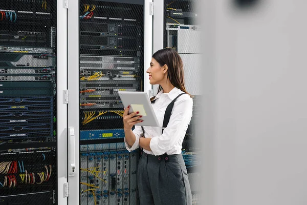 Technician analyzing server in server room