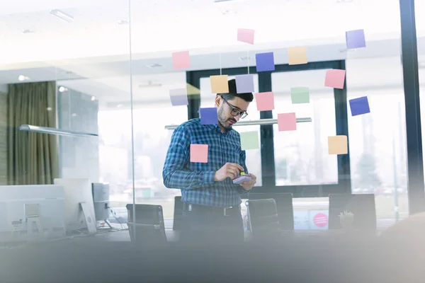 Empresario Leyendo Notas Adhesivas Pared Vidrio Oficina Analizándolas — Foto de Stock