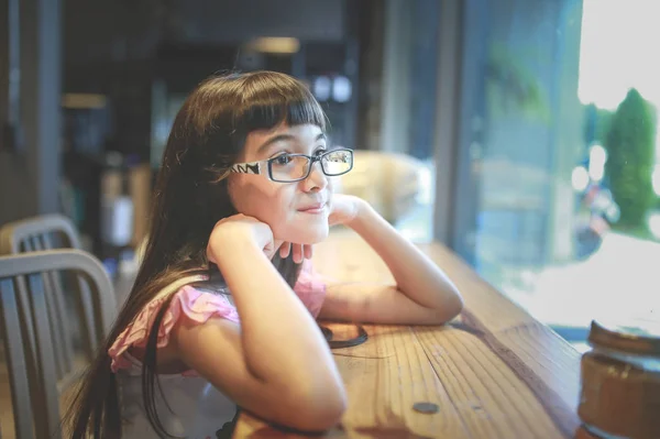 Asiatische Kinder mit Brille lesen gerade ein Buch in einem Kaffee — Stockfoto