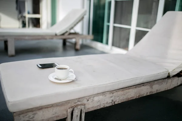 Café y MobilePhone en una silla con piscina en el complejo — Foto de Stock