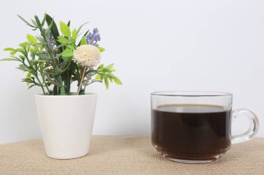 Kahve ve donut beyaz bir masada siyah kahve çekirdekleri