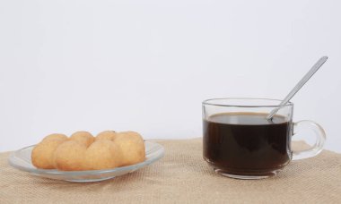 Kahve ve donut beyaz bir masada siyah kahve çekirdekleri