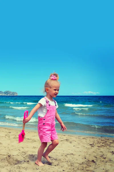 Menina brincando na areia na praia — Fotografia de Stock