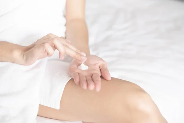 Kadın ellerine nemlendirici krem sürüyor. Güzellik konsepti.