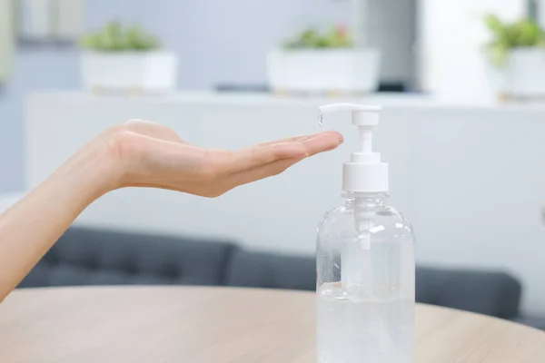 El dezenfektanı jel pompası kullanan kadın elleri. Pompa şişesindeki temizleyici mikropları, bakterileri ve virüsü öldürmek için.