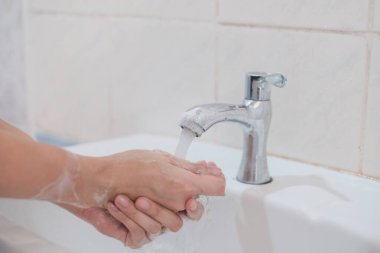 Kadın ellerini yıkıyor, Corona virüsü önlüyor, ellerini sabun ve sıcak suyla yıkıyor. Coronavirüs salgını için el hijyeni. El yıkama ile korunma sıklıkla kabul edilir.