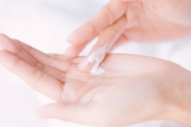 Kapat kadın nemlendirici krem / losyon sürüyor ellerine, Top View, güzellik konsepti.